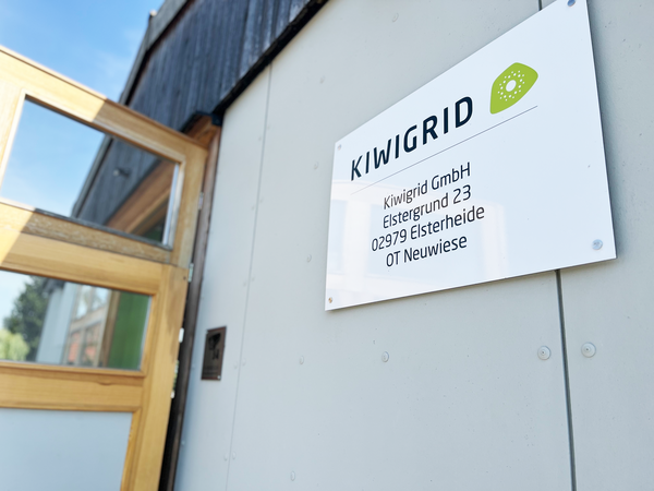 Entrance sign with Kiwigrid logo and address of Energiepark Neuwiese.